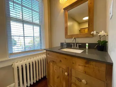 a bathroom with a sink and a mirror and a radiator at THE LEMON TREE - DOWNTOWN HISTORIC LANCASTER in Lancaster