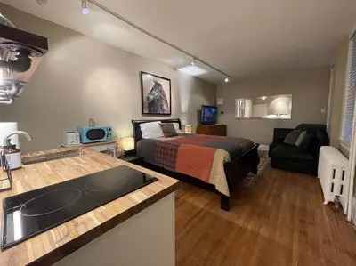 a bedroom with a bed and a kitchen with a sink at THE LIMÓNETTA - STUDIO IN HISTORIC LANCASTER in Lancaster