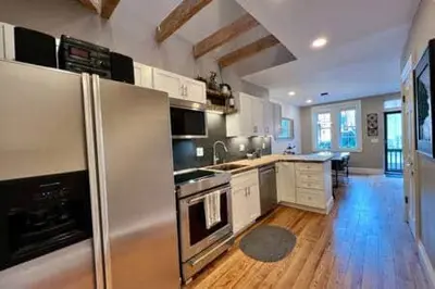 a kitchen with stainless steel appliances and wooden floors at THE CONESTOGA HOUSE - THEATER & BUSINESS DISTRICT in Lancaster