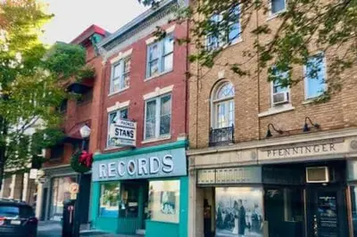 a store on a street next to a brick building at THE CONESTOGA HOUSE - THEATER & BUSINESS DISTRICT in Lancaster