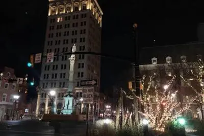 a city at night with a large building with christmas lights at THE CONESTOGA HOUSE - THEATER & BUSINESS DISTRICT in Lancaster