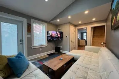 a living room with a white couch and a table at THE CONESTOGA HOUSE - THEATER & BUSINESS DISTRICT in Lancaster