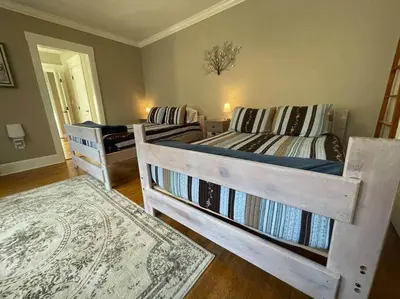a room with two beds and a rug at BLETCHER GARDEN LOFT - LANCASTER HISTORIC DISTRICT in Lancaster