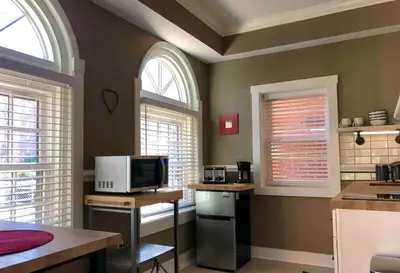 a kitchen with two arched windows and a microwave at THE STEVENS STUDIO - HISTORIC DOWNTOWN LANCASTER in Lancaster