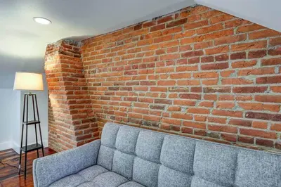 a couch in front of a brick wall at THE HAMILTON HOUSE - DOWNTOWN COLONIAL LANCASTER in Lancaster