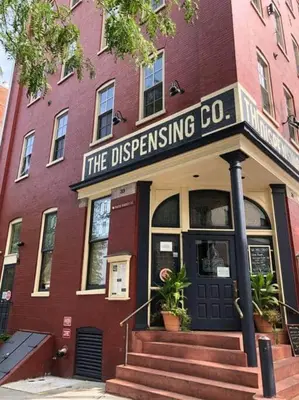 a red brick building with a sign for the dispensing company at THE HAMILTON HOUSE - DOWNTOWN COLONIAL LANCASTER in Lancaster