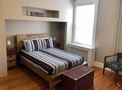 a bedroom with a bed and a chair and a window at THE ROYER HOUSE - LANCASTER'S HISTORIC DISTRICT in Lancaster