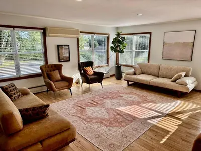 a living room with couches and chairs and windows at Honesdale in Honesdale