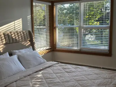 a bedroom with a large bed with two windows at Honesdale in Honesdale