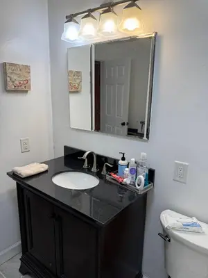a bathroom with a sink and a mirror at BedRoom with half bathroom in Ridgefield Park