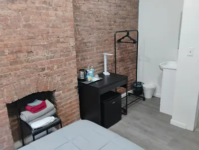 a room with a brick wall and a black desk at Aycee 417 in New York