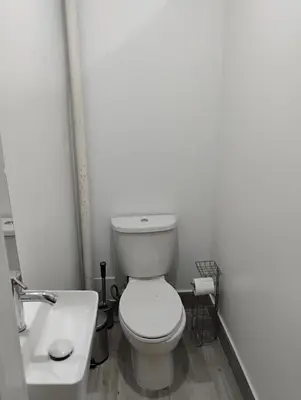 a white bathroom with a toilet and a sink at Aycee 417 in New York