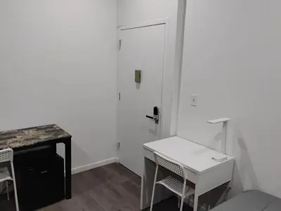 a white room with a desk and a door at Aycee 417 in New York