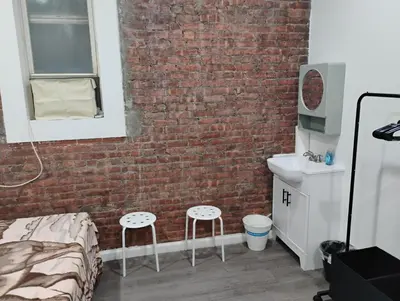 a bedroom with a brick wall and a bed and a sink at Aycee 417 in New York