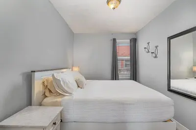 a white bedroom with a bed and a mirror at Stay on State in Duncannon