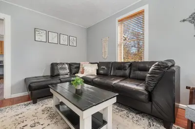 a living room with a leather couch and a table at Stay on State in Duncannon