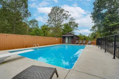 a swimming pool in a backyard with a fence at Happy Trails House in Liverpool