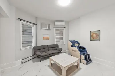 a living room with a couch and a table at 5MIN walk NYC Train Massage Chair Sleeps 12Plus in Bayonne