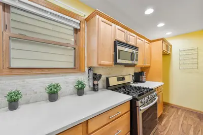 a kitchen with a stove and a microwave at 5MIN walk NYC Train Massage Chair Sleeps 12Plus in Bayonne
