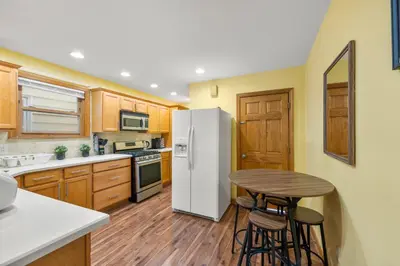 a kitchen with a white refrigerator and a table at 5MIN walk NYC Train Massage Chair Sleeps 12Plus in Bayonne