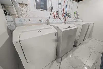 a white laundry room with three washing machines at 5MIN walk NYC Train Massage Chair Sleeps 12Plus in Bayonne