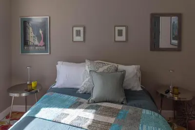a bedroom with a bed with two tables and two mirrors at An Locha B&B