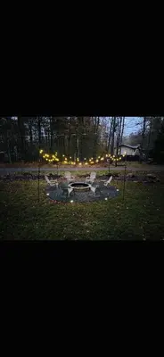 a park with two chairs and a fountain in the grass at Lake Access, Hot Tub, Fire Pit in Arrowhead Lake
