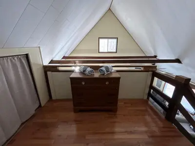 a attic room with a dresser and a window at Lake Access, Hot Tub, Fire Pit in Arrowhead Lake
