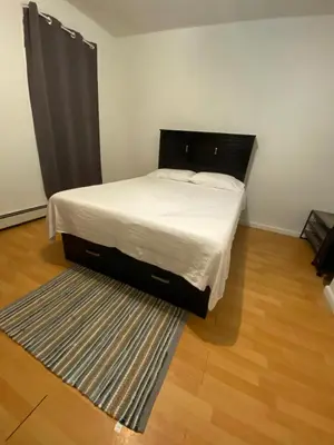 a bed in a small room with a rug at Private Room near NYC! in Paterson
