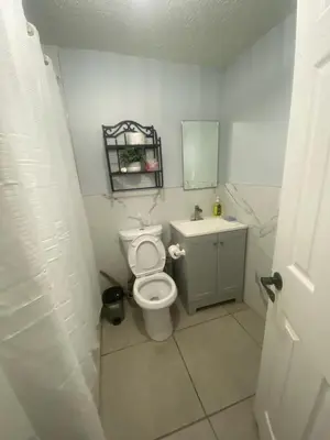 a bathroom with a toilet and a sink and a mirror at Private Room near NYC! in Paterson