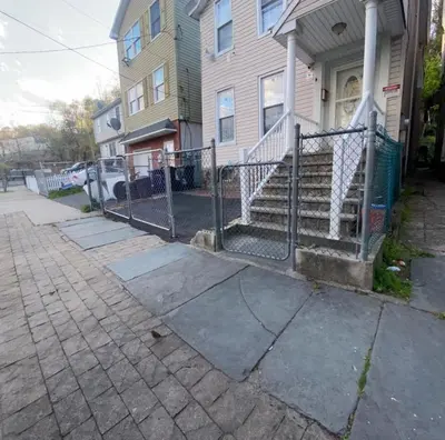 a fence in front of a house with stairs at Private Room near NYC! in Paterson