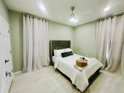 a bedroom with a large bed with white curtains at 3 Large Bedrooms Luxe Artistic Art Vibe in Newark