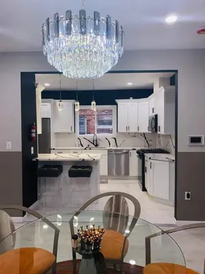 a kitchen with a glass table and a chandelier at 3 Large Bedrooms Luxe Artistic Art Vibe in Newark