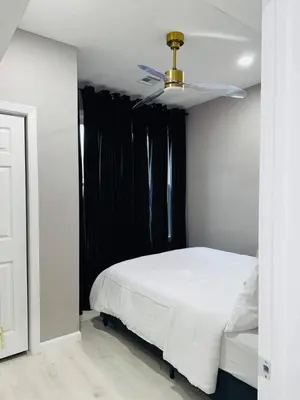 a bedroom with a white bed and a ceiling fan at 3 Large Bedroom Designer house Spacious in Newark