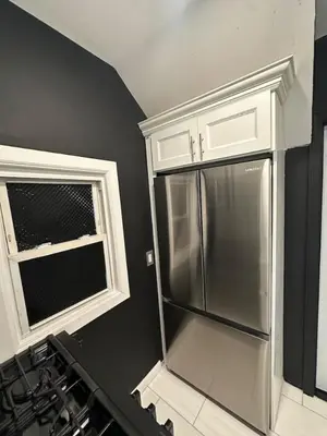 a kitchen with a stainless steel refrigerator and a window at 1 Large Bedroom Contemporary Luxe Stay in Newark