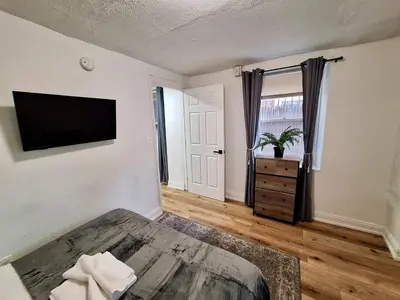 a bedroom with a bed and a television on a wall at Brand New 1BR in Center City with Private Backyard in Philadelphia