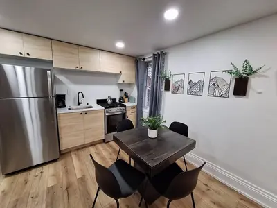 a kitchen with a table and chairs and a refrigerator at Brand New 1BR in Center City with Private Backyard in Philadelphia