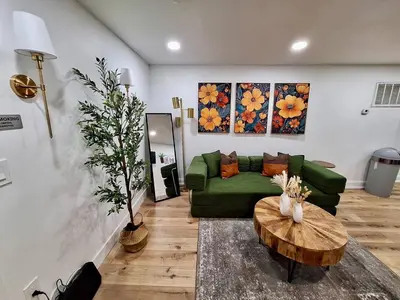 a living room with a green couch and a table at Brand New 1BR in Center City with Private Backyard in Philadelphia