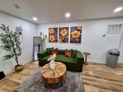 a living room with a green couch and a table at Brand New 1BR in Center City with Private Backyard in Philadelphia
