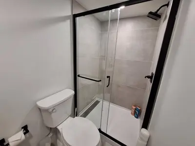 a bathroom with a toilet and a glass shower at Brand New 1BR in Center City with Private Backyard in Philadelphia