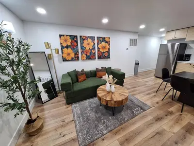 a living room with a green couch and a table at Brand New 1BR in Center City with Private Backyard in Philadelphia