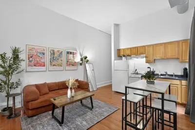 a living room with a couch and a kitchen at Large 1 BR in Center City with Double Queen Beds and King Sleeper Sofa) in Philadelphia