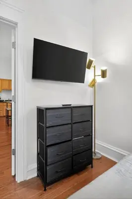 a bedroom with a dresser with a flat screen tv on a wall at Large 1 BR in Center City with Double Queen Beds and King Sleeper Sofa) in Philadelphia