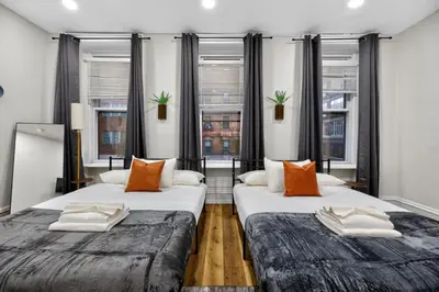 two beds in a room with two windows at Brand New 2BR in the Heart of Center City that Sleeps 14 people in Philadelphia