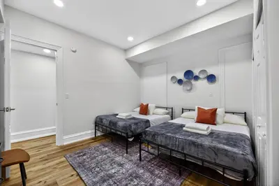 two beds in a room with white walls at Brand New 2BR in the Heart of Center City that Sleeps 14 people in Philadelphia