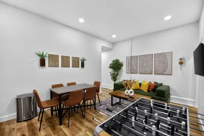 a living room with a table and a green couch at Brand New 2BR in the Heart of Center City that Sleeps 14 people in Philadelphia