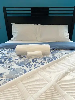 a bed with two rolled towels on it at Peace Haven Stay in Newark