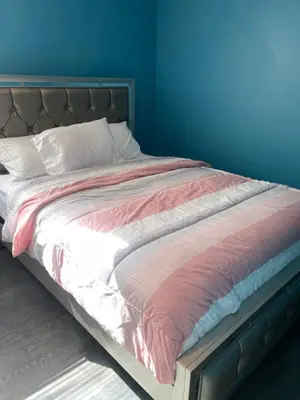 a bed in a room with a blue wall at Peace Haven Stay in Newark