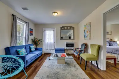a living room with a blue couch and a table at Lakefront Pocono Retreat with Hot Tub and Movie Hub in Pocono Summit
