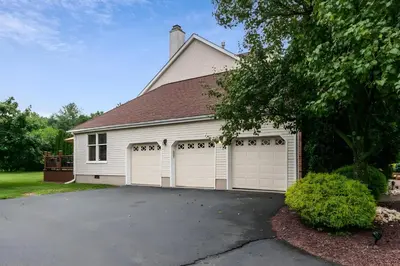 a white house with two garage doors at 5 Mi to Princeton Family Home with Deck and Yard! in Dutch Neck